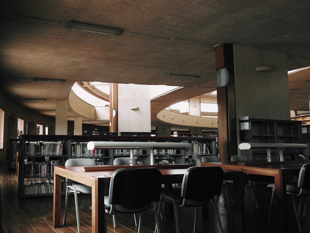 brown wooden desk with chairs inside the room