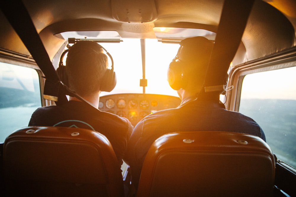 two men piloting plane during daytime