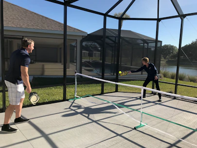 A dynamic doubles pickleball match showing players coordinating a strategic play.