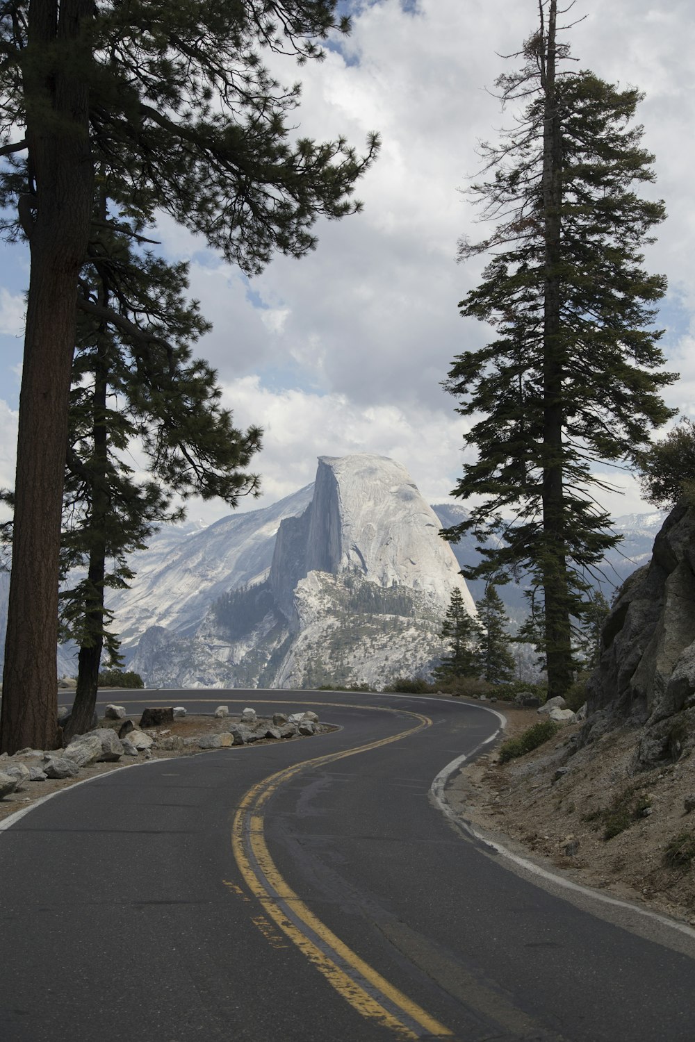 snow covered mountain in front of road during daytime