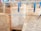 Several pages of old text with faded writing are clipped to clotheslines using blue and grey clothespins. The setup appears to be against a brick or textured wall, hinting at an informal preservation or drying process.