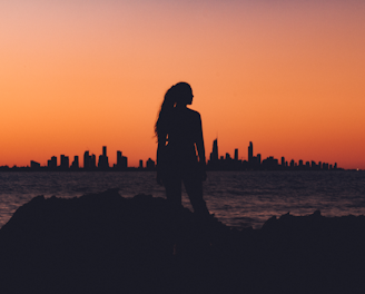 silhouette of woman near shoreline