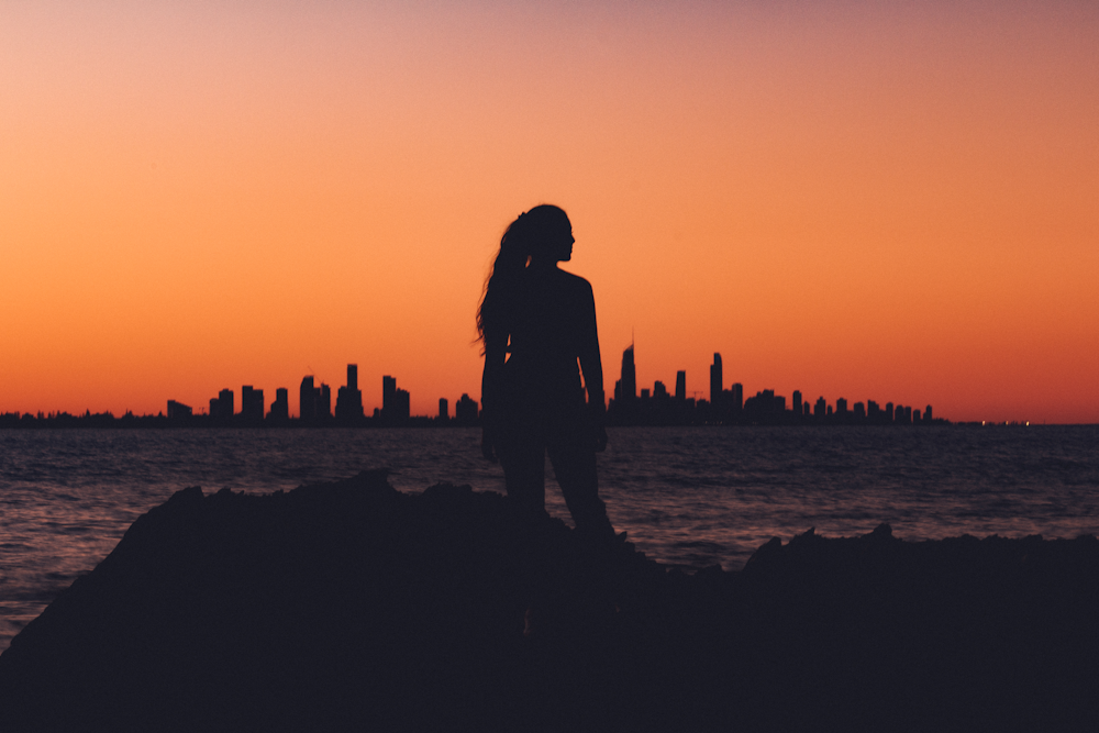 silhouette of woman near shoreline