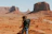 woman with black backpack standing on brown dessert