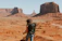 woman with black backpack standing on brown dessert