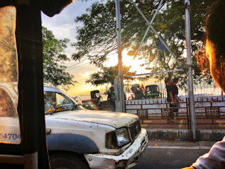 A friendly technician removing a car wreck in a suburban street at sunset.