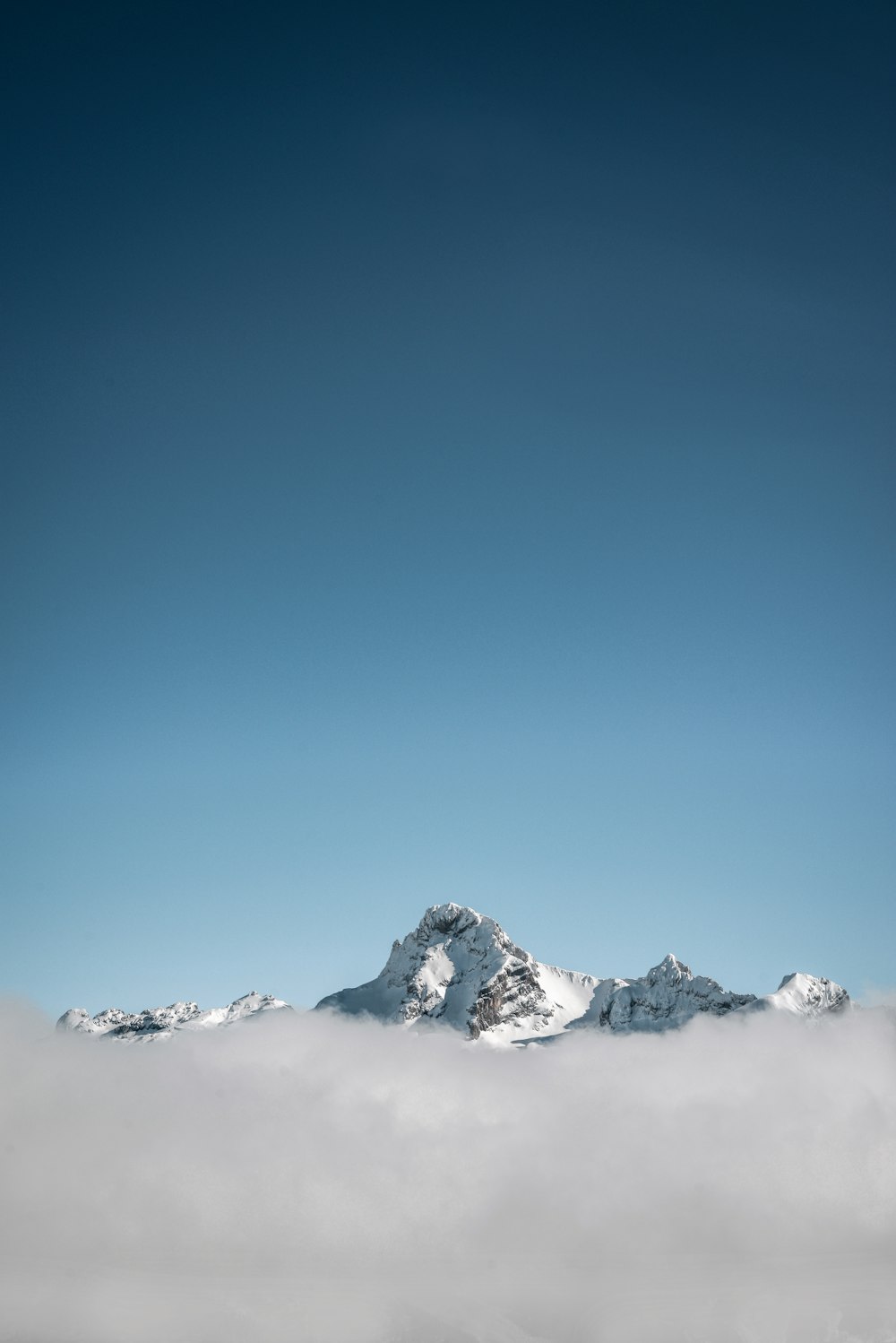 selective focus photography of white mountain under blue calm sky