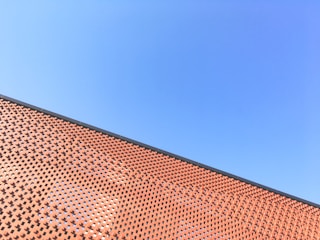 Image of skilled masonry workers building a brick wall on a sunny day.