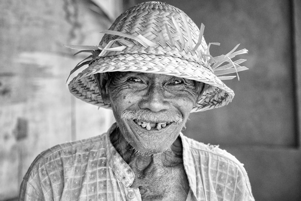 grayscale photo of man smiling wearing straw hat