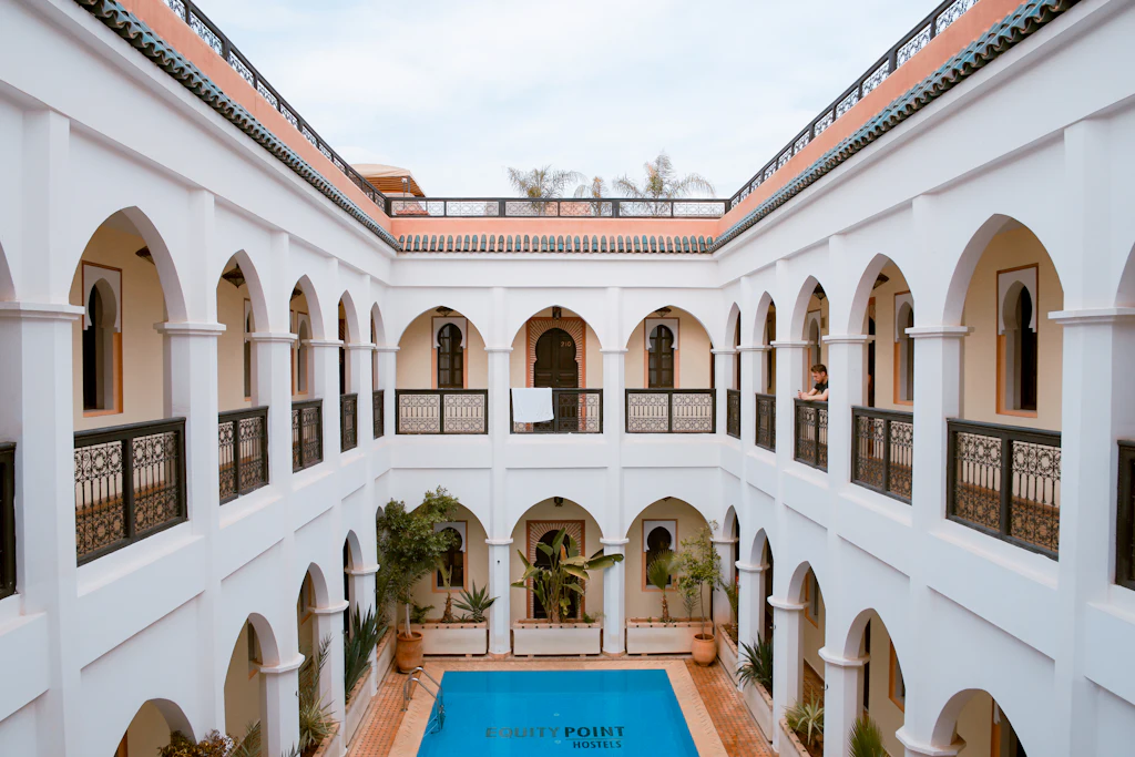 A sunlit courtyard with arches and a pool