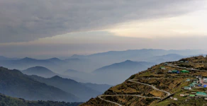 A scenic view of Kodaikanal hills shrouded in mist with a winding road inviting travelers.