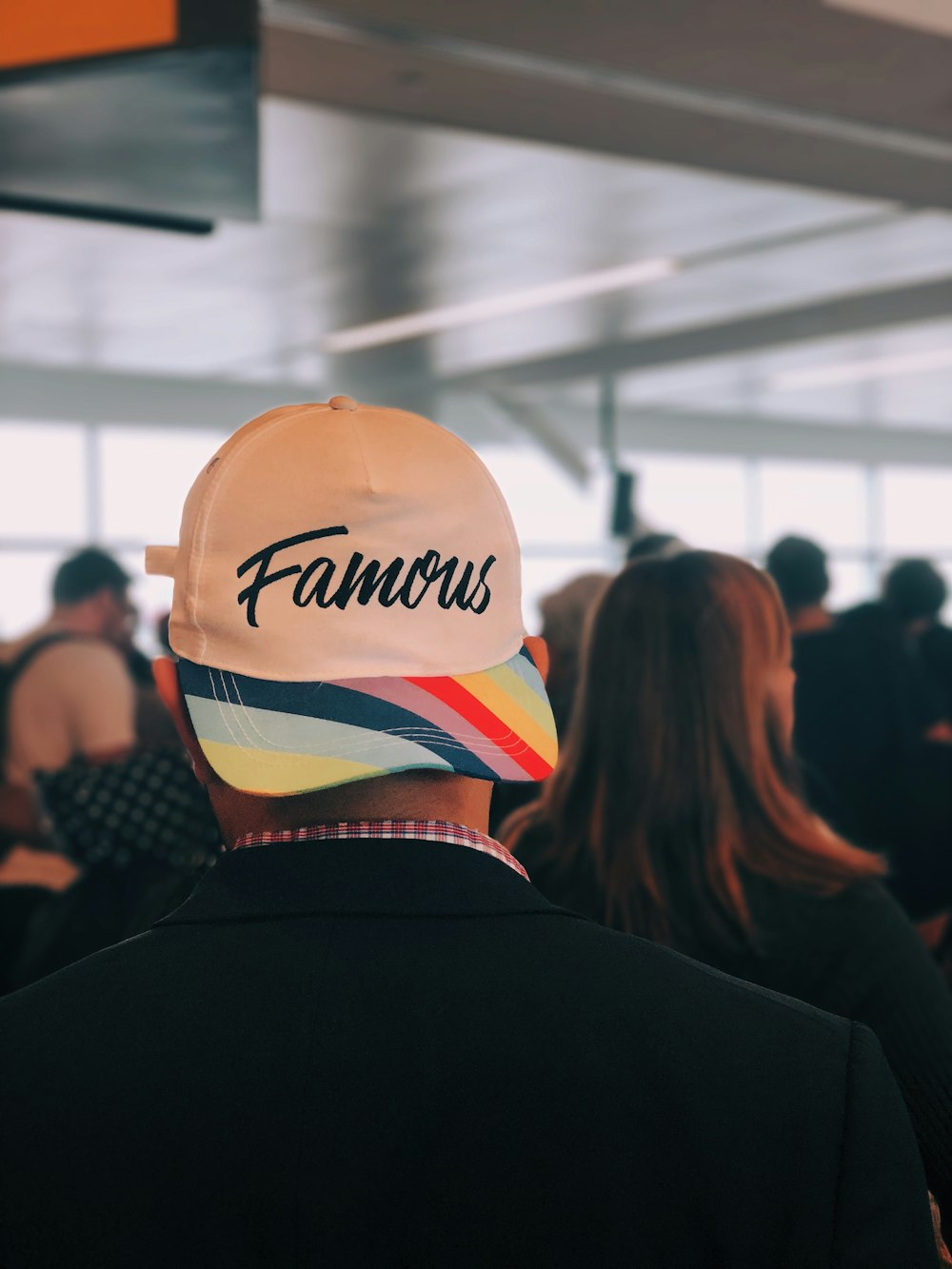 man wearing multicolored Famous cap