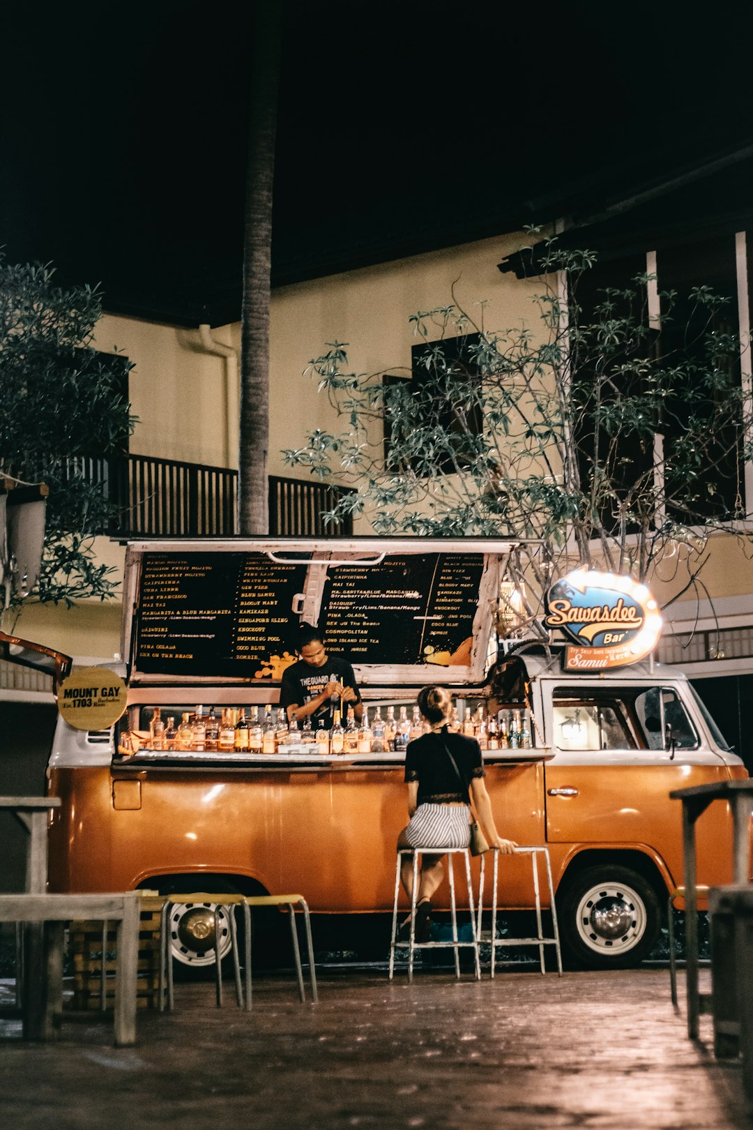 man sit on stool in front of recreational vehicle