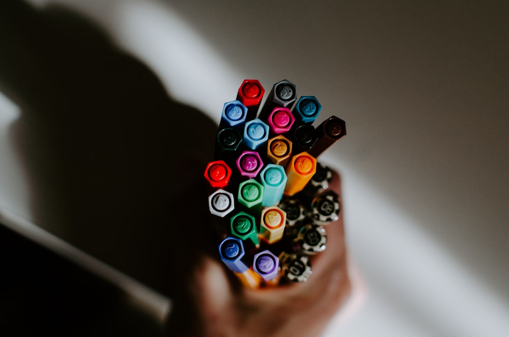 a person holding a bunch of crayons in their hand