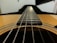 A close-up of a nylon-string guitar resting on a wooden table.