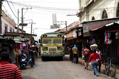 A busy bus wrapped in colorful advertising driving through a bustling street.