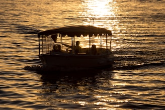 A small group of travelers enjoying a sunset cruise on a traditional wooden boat near Nosy Be.