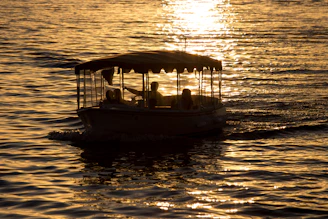 A serene electric boat gliding silently over crystal-clear Mediterranean waters at sunset.