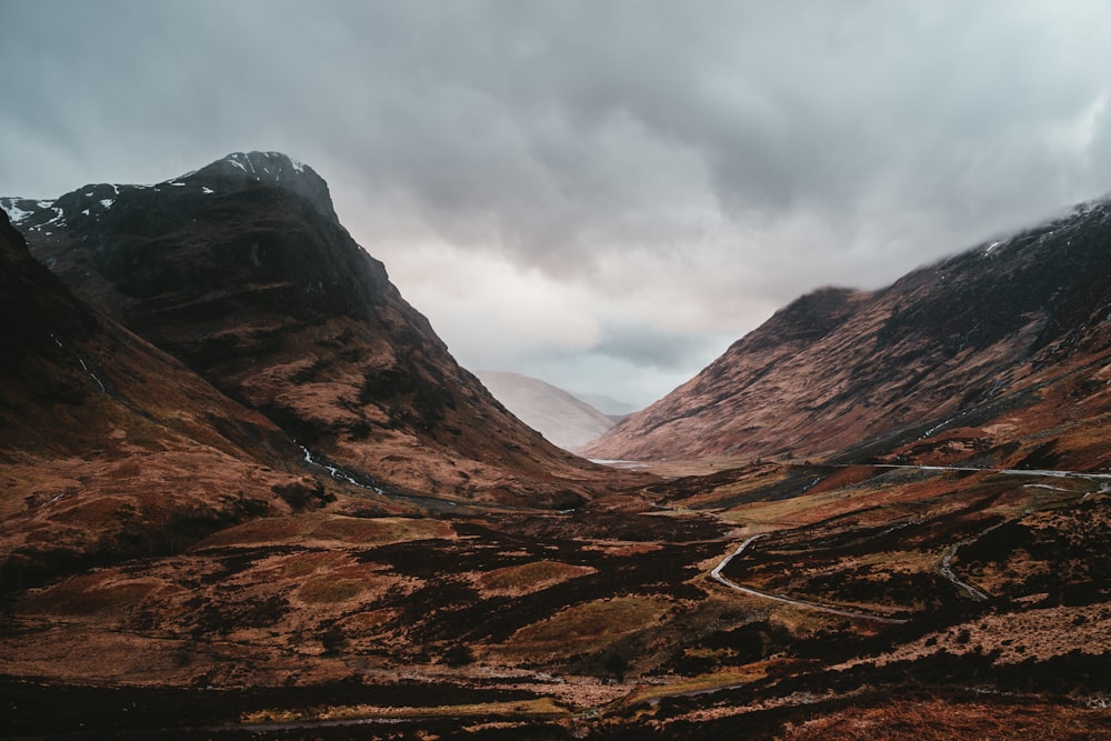 mountain near road under clouds