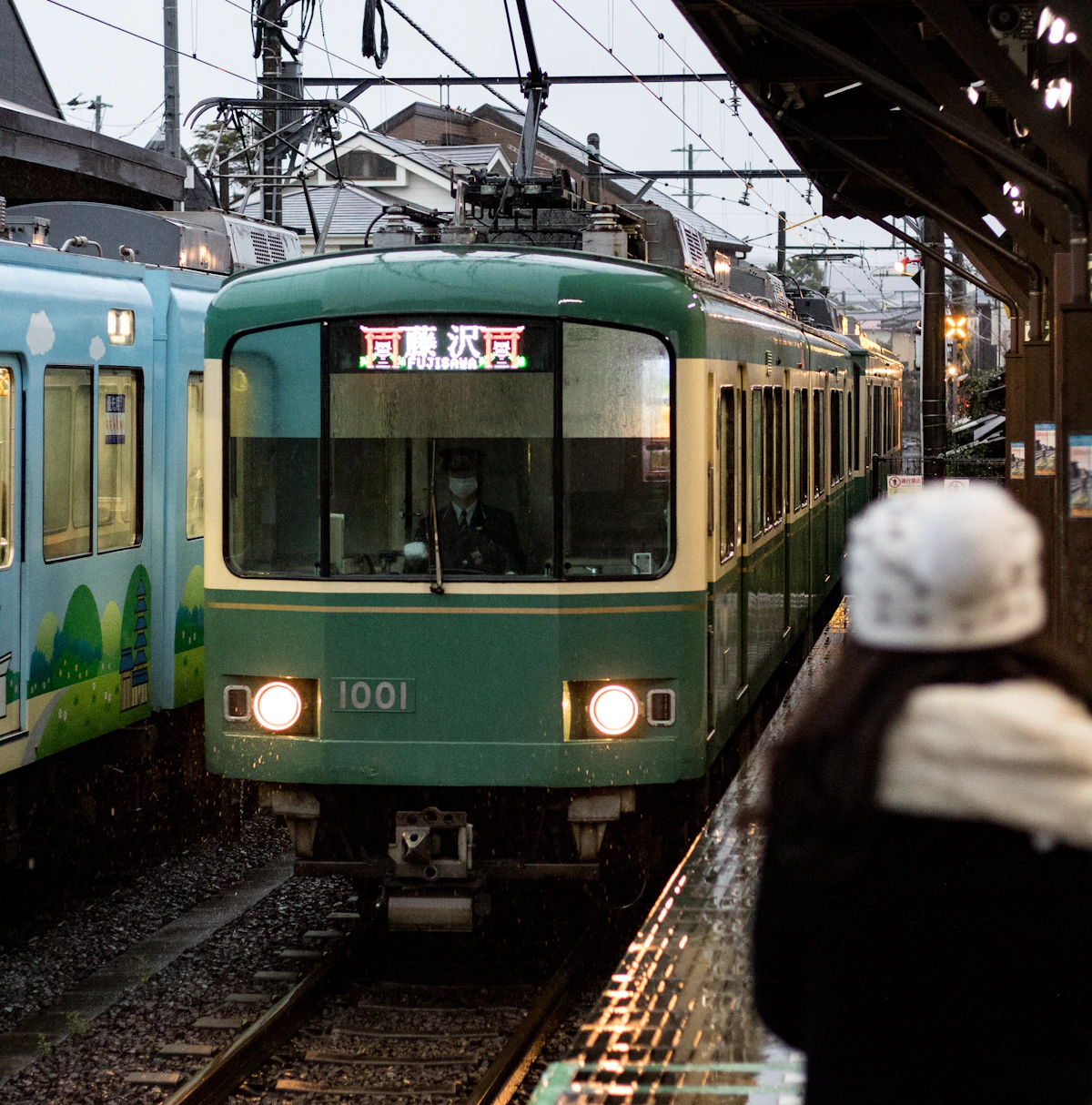 A local train passing a small station platform in Japan