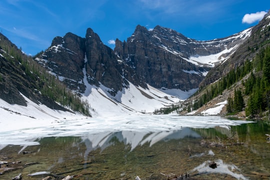 lake surrounded with mountain covered with snoe in Lake Agnes Canada