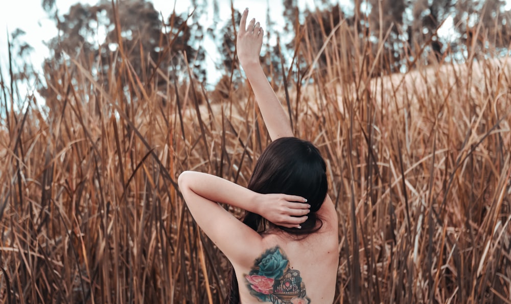 woman naked stand beside plants