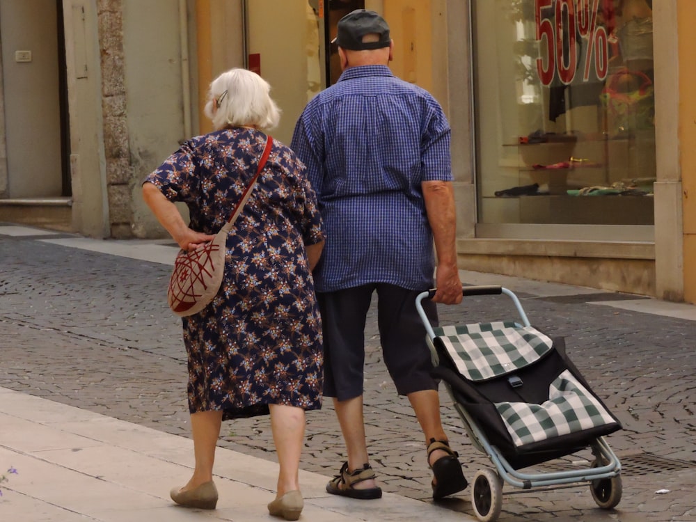 man and woman walking on street with stroller