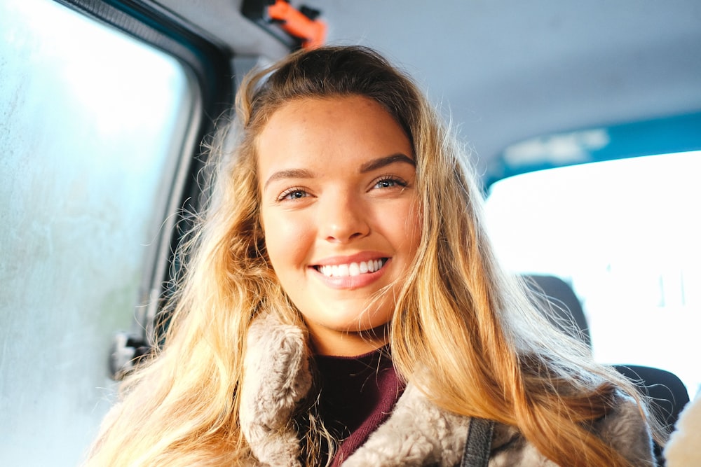 femme souriante assise dans le véhicule