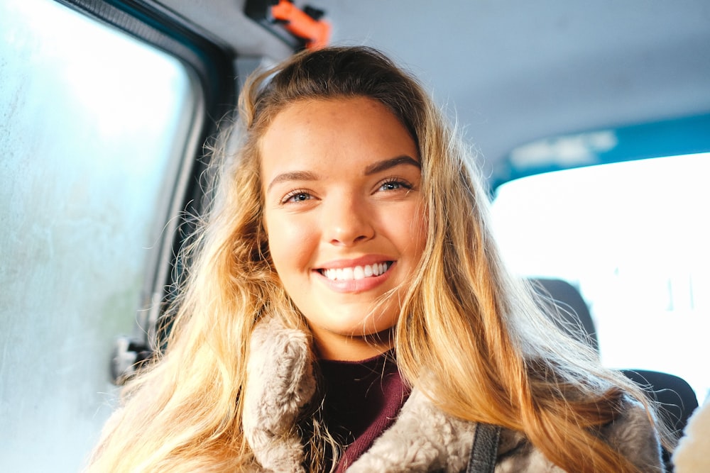smiling woman sitting in vehicle