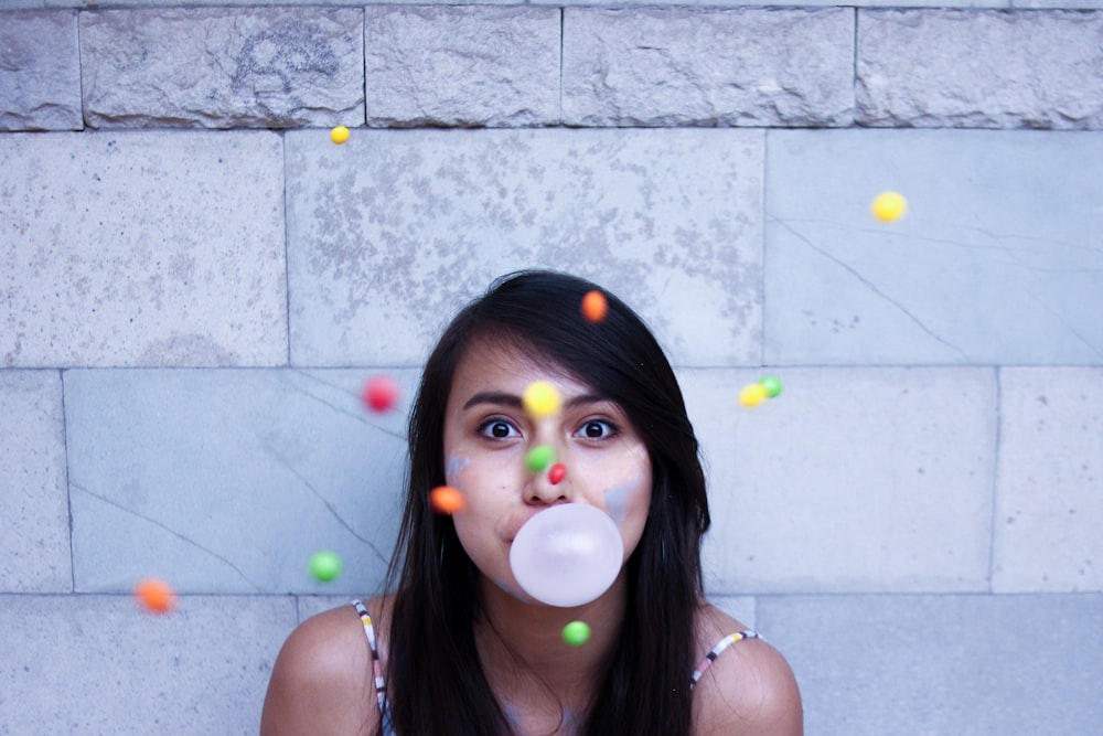 time lapse photo of woman making gum bubble