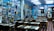 The interior of a cozy restaurant is decorated with numerous framed photographs and posters on the walls, creating a nostalgic atmosphere. Wooden tables and chairs are arranged neatly throughout the room, with patrons sitting and enjoying their meals. The lighting is soft, complementing the vibrant blue walls.