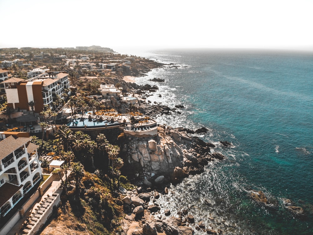 Fotografia panorâmica de arquiteturas e oceano azul sob céu azul