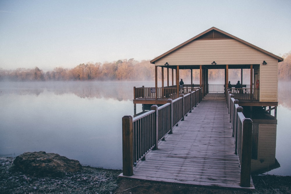 brown wooden house near body of water during daytime