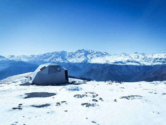 gray dome tent on snow surface overlooking snow capped mountain under blue sky at daytime in Sendero Cerro Provincia Chile