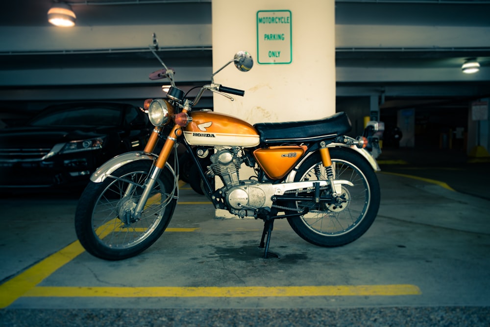 A motorbike parked in a car park with a parking bay for motorcycles. 