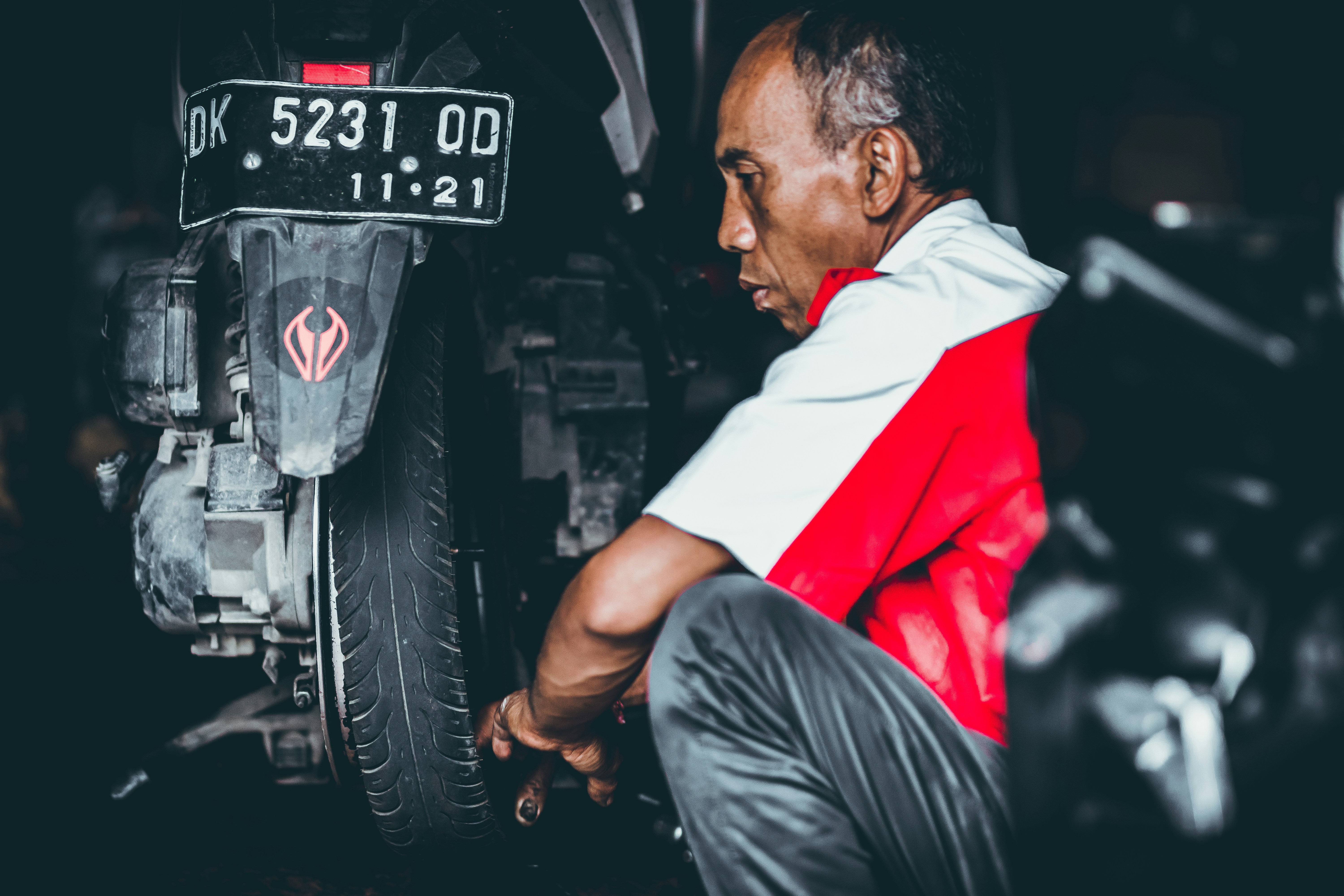 Mechanic inspecting an electric vehicle’s all-season tire in a service bay