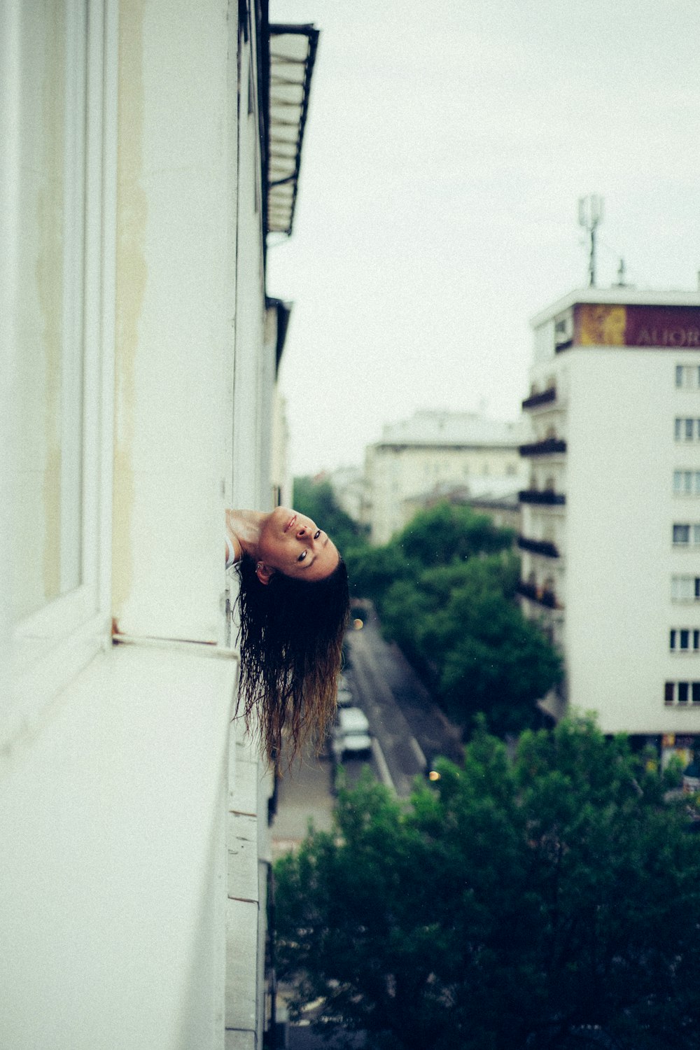 woman with hear head outside the window