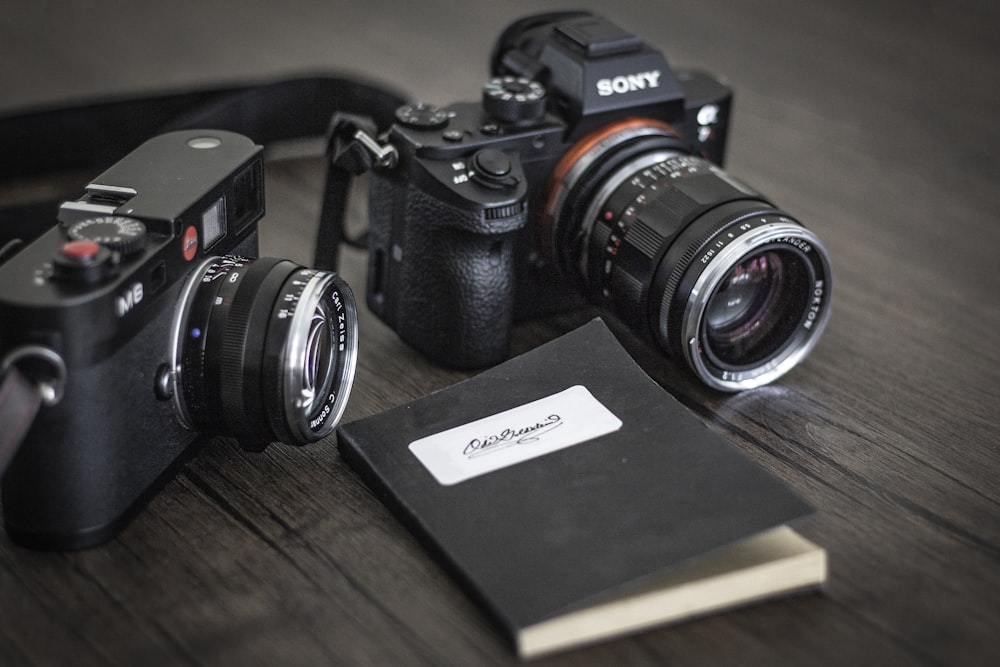 fotocamera mirrorless Sony nera vicino ad altre fotocamere mirrorless e notebook
