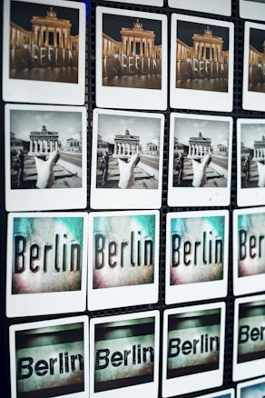 A grid of photos displaying various views and artistic representations of Berlin, including images of the Brandenburg Gate in color and black and white, as well as stylized text images of the word 'Berlin'.