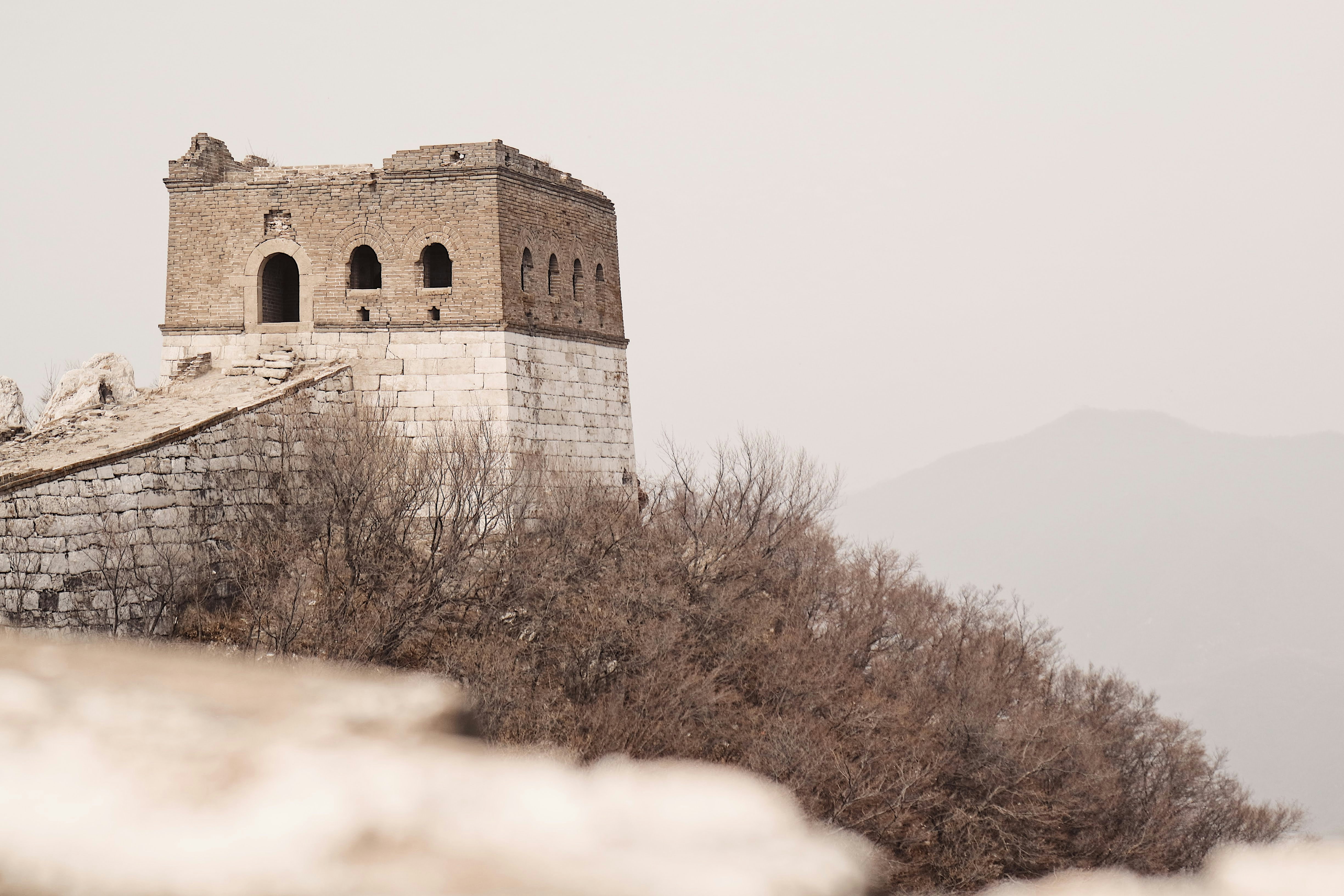 brown concrete building, Walking the lesser trodden lengths of the Great Wall was one of the highlights of the trip to China. The beauty of the wall as it starts to be enveloped by and changed by the nature that surrounds it was mesmerising.