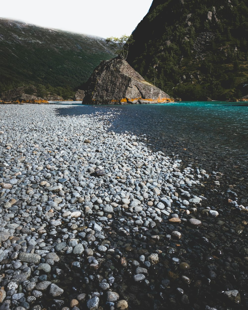 曇り空の下の山の近くの水域