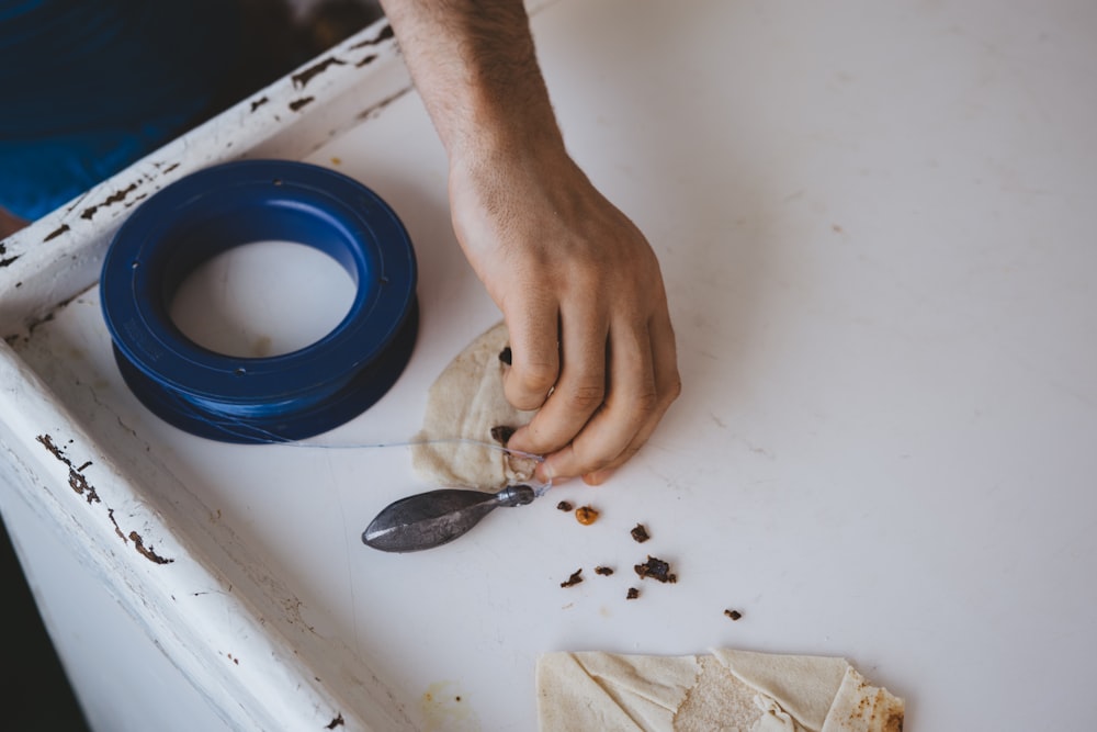 person holding gray metal part