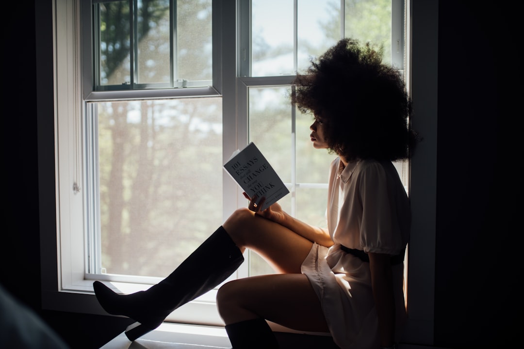 mulher inteligente lendo livro na janela