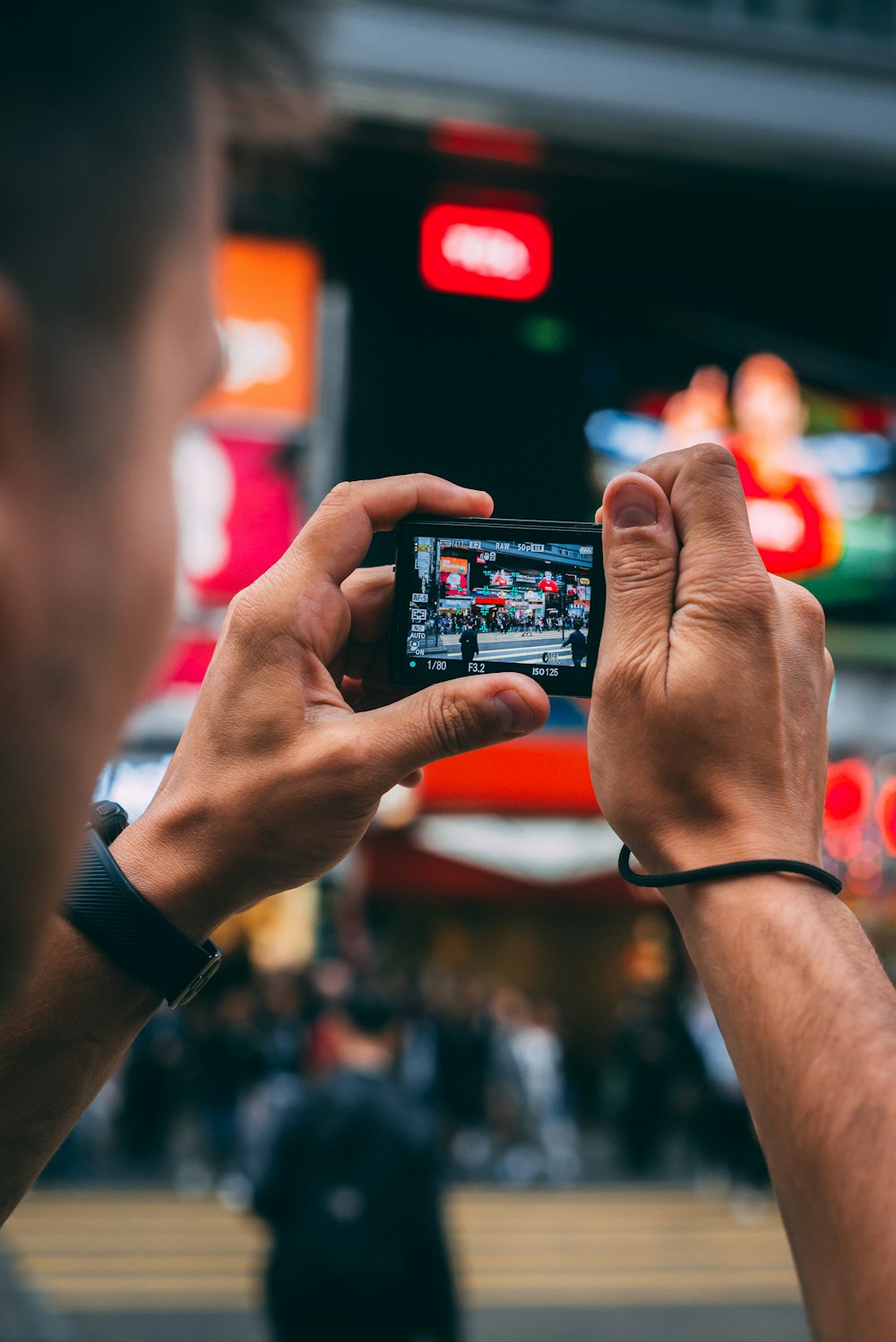 man capturing several people on street selective focus photo