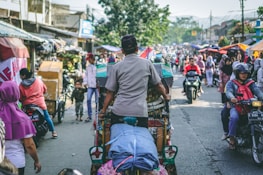 selective photography of man pedaling wagon