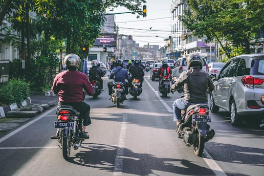 motorcycles and vehicles on road at daytime in Bandung Indonesia