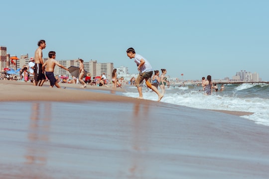 people on beach during daytime in Rockaway Beach United States
