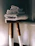 A neatly folded stack of colorful Velora face towels on a wooden shelf with soft natural light.