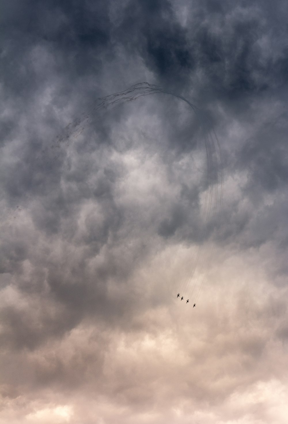 silhouette of four aircraft flying near clouds