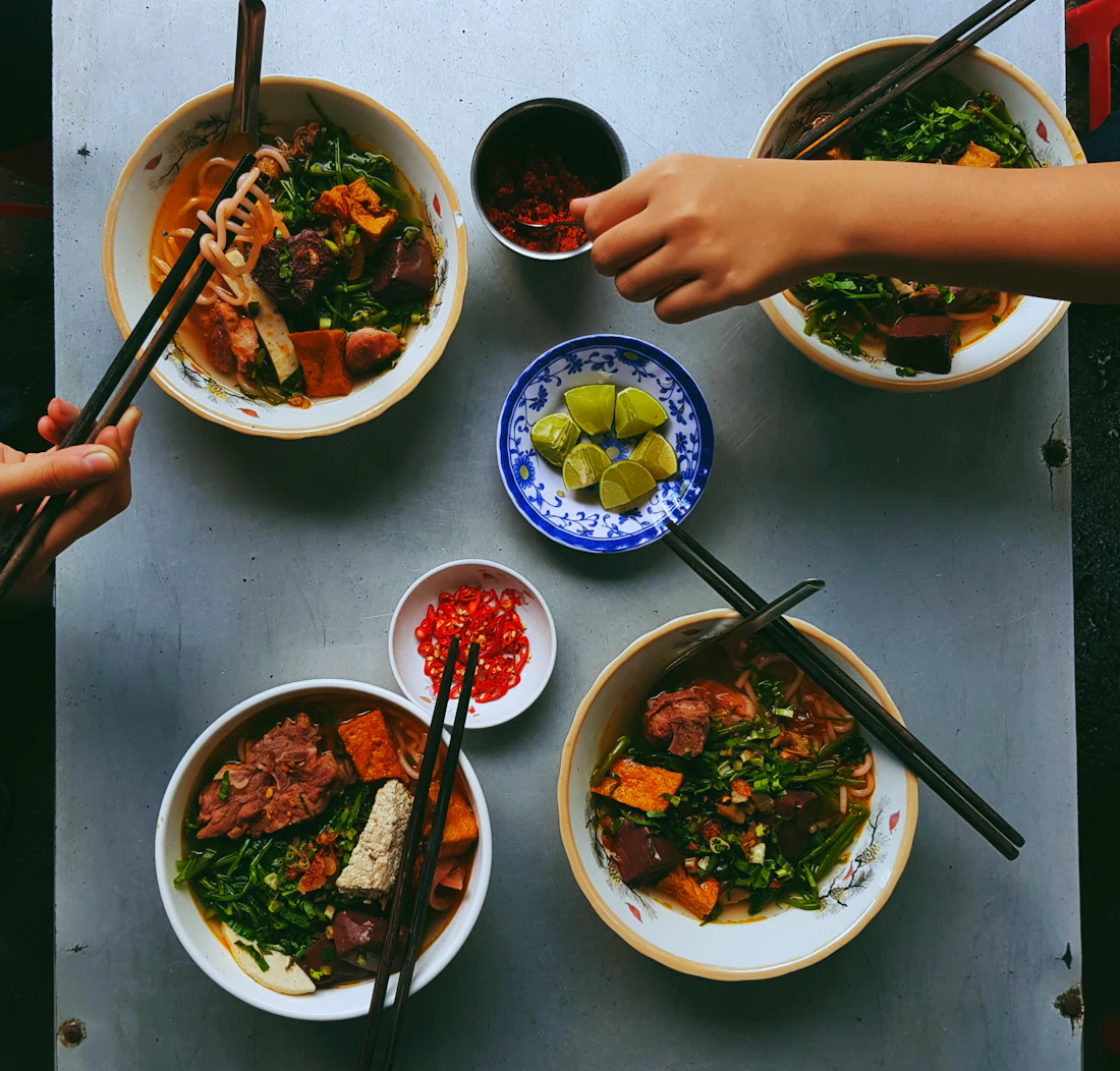 A bowl of noodles being eaten with chopsticks